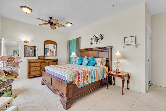 bedroom featuring light tile patterned flooring, a textured ceiling, and a ceiling fan