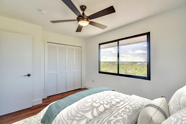 bedroom featuring a closet, wood finished floors, a ceiling fan, and baseboards