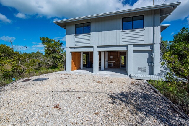 rear view of property with a carport and driveway