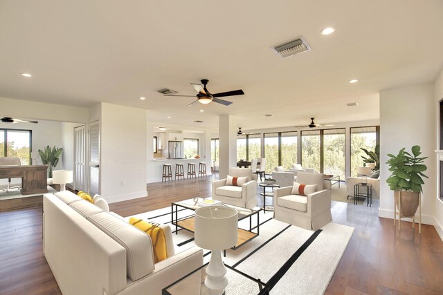 living area featuring a healthy amount of sunlight, wood-type flooring, and visible vents