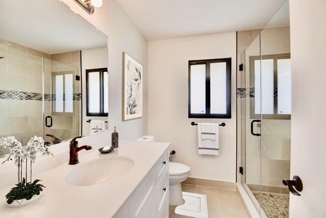 full bathroom with vanity, a shower stall, toilet, and tile patterned floors