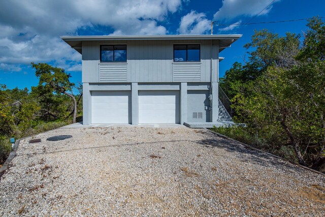 view of front of property featuring a garage and gravel driveway