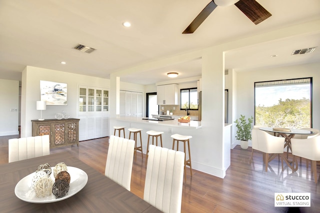 dining area featuring baseboards, visible vents, radiator, wood finished floors, and recessed lighting