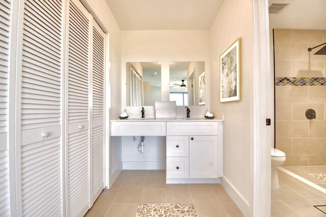 full bathroom with toilet, a tile shower, a closet, and tile patterned floors