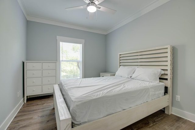 bedroom with baseboards, ornamental molding, and wood finished floors