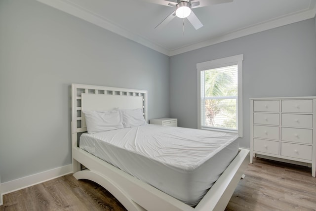 bedroom with ceiling fan, ornamental molding, light wood-type flooring, and baseboards