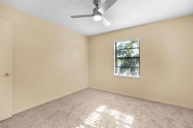 spare room featuring ceiling fan, baseboards, a textured ceiling, and light colored carpet