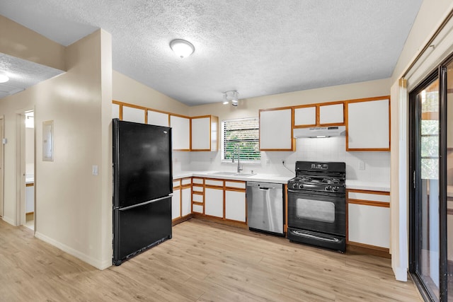 kitchen with under cabinet range hood, a sink, white cabinetry, light countertops, and black appliances