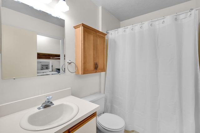 full bathroom with toilet, a textured ceiling, and vanity