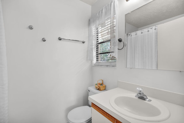 full bathroom with a textured ceiling, a shower with shower curtain, vanity, and toilet