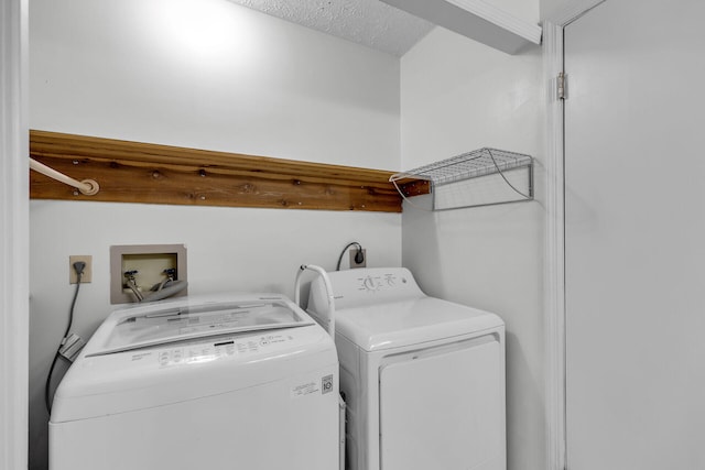 laundry room featuring a textured ceiling, laundry area, and separate washer and dryer
