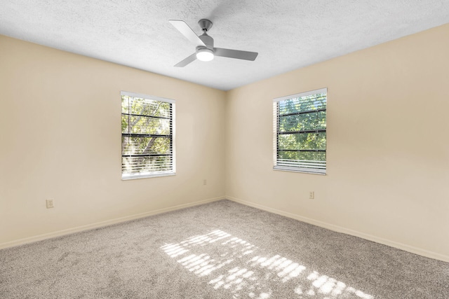 spare room featuring a ceiling fan, carpet, baseboards, and a textured ceiling