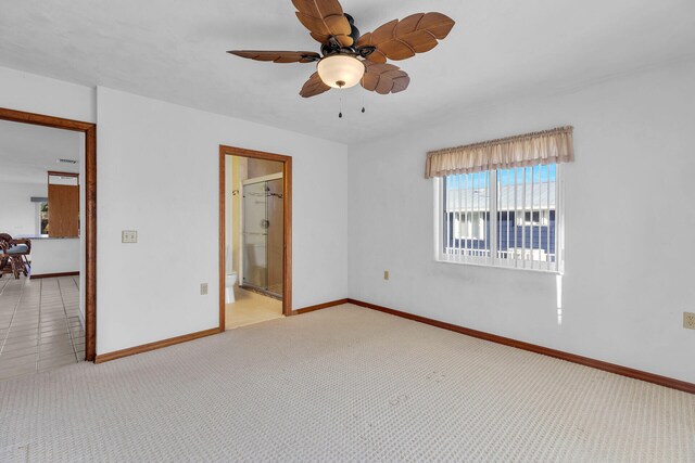 unfurnished bedroom featuring ceiling fan, baseboards, ensuite bathroom, and carpet flooring