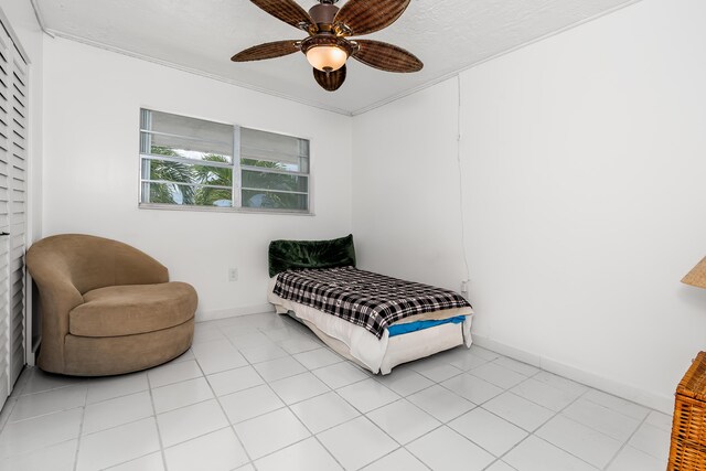 bedroom with ceiling fan, baseboards, and light tile patterned floors