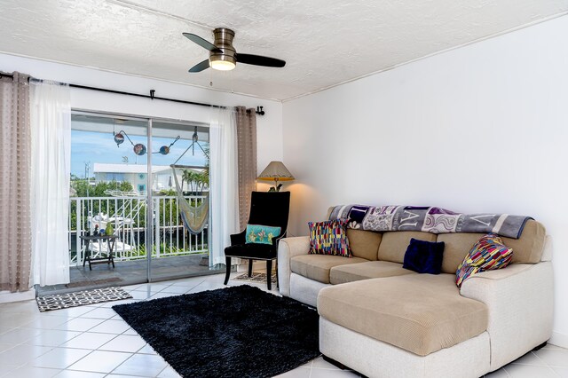 living area featuring a textured ceiling, light tile patterned floors, and a ceiling fan