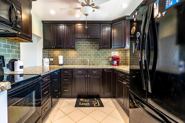 kitchen featuring dark brown cabinetry, black appliances, and light stone countertops