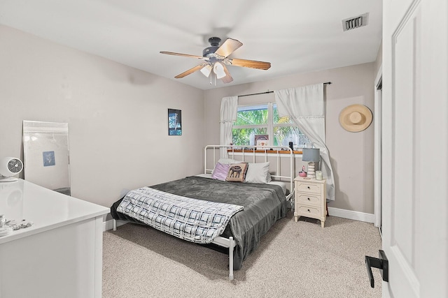 bedroom featuring light colored carpet, visible vents, ceiling fan, and baseboards