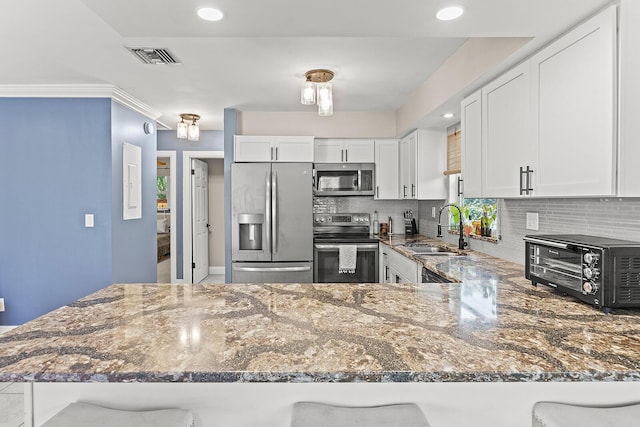 kitchen with stainless steel appliances, white cabinets, and a peninsula