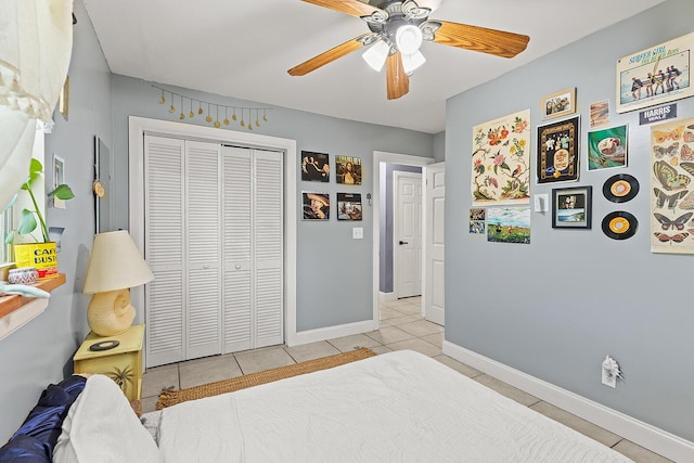 bedroom featuring a ceiling fan, baseboards, a closet, and light tile patterned flooring