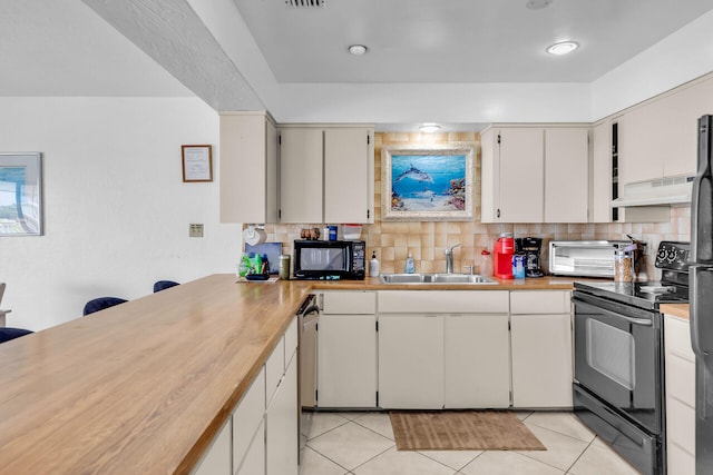 501 9th St, Key Colony, FL 33051 - kitchen featuring a sink, black appliances, under cabinet range hood, and tasteful backsplash