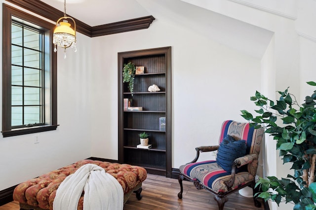 living area with ornamental molding, plenty of natural light, built in shelves, and wood finished floors