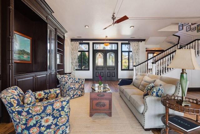 living area with light wood-style floors, stairway, and french doors