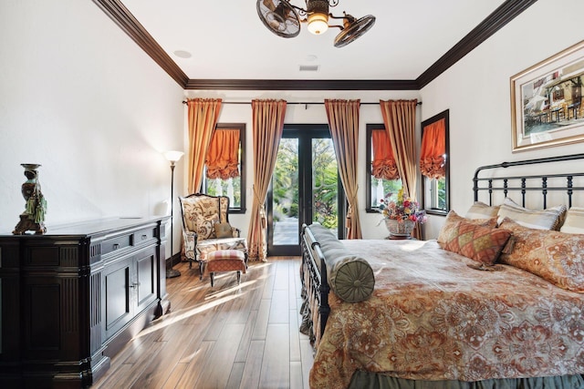 bedroom featuring crown molding, wood finished floors, visible vents, and access to exterior