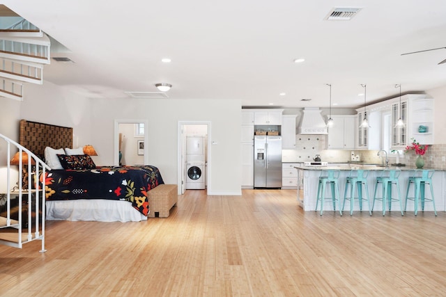 kitchen with washer / clothes dryer, glass insert cabinets, white cabinets, premium range hood, and stainless steel fridge with ice dispenser