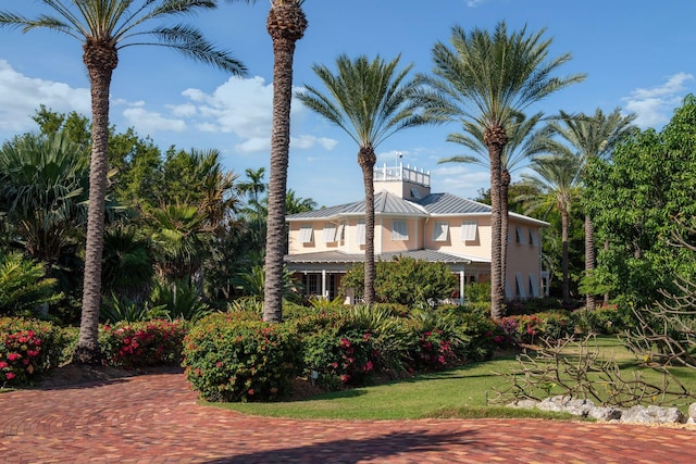 view of front of property featuring a standing seam roof, metal roof, and a front lawn