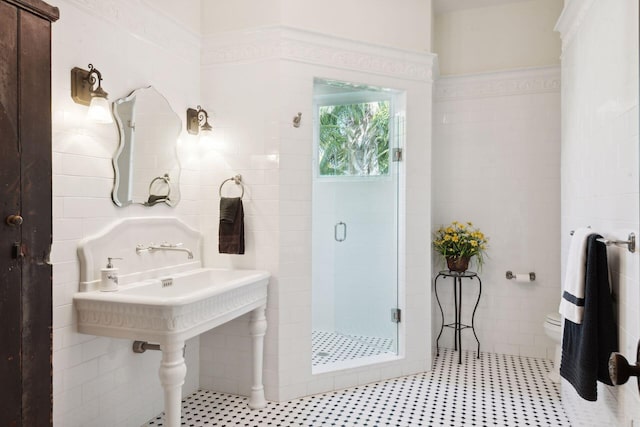 full bath with tile walls, tile patterned flooring, a shower stall, and toilet