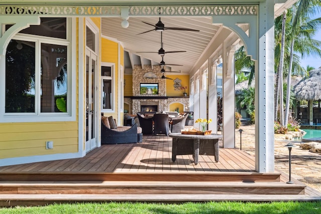 wooden deck featuring an outdoor stone fireplace