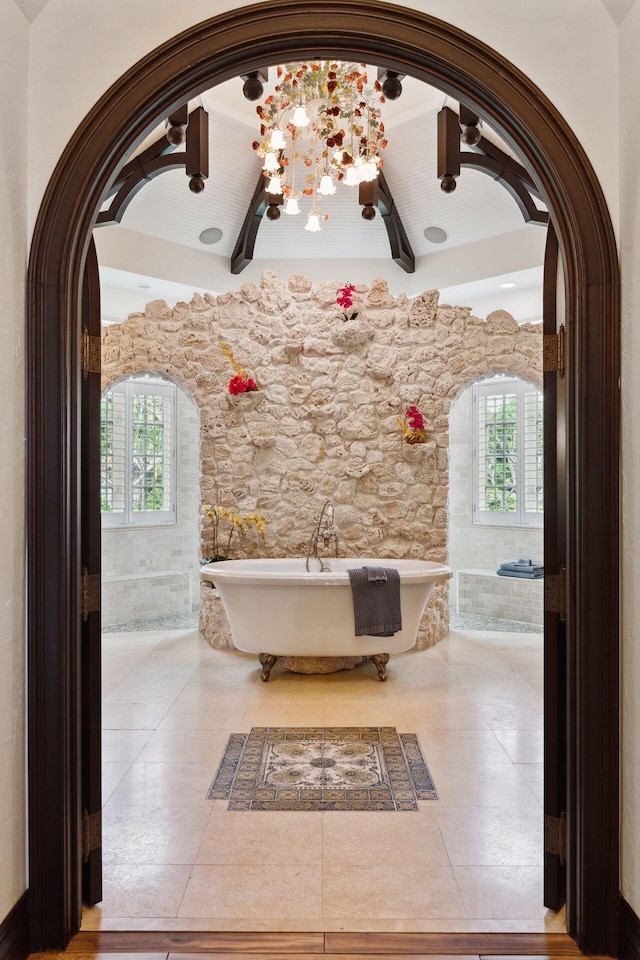 full bath with a wealth of natural light, a soaking tub, and tile patterned floors