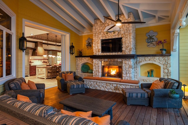 interior space featuring lofted ceiling with beams and a stone fireplace