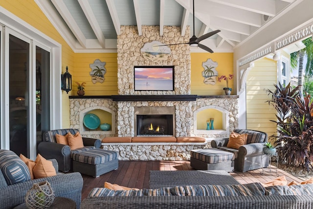 exterior space featuring lofted ceiling with beams, ceiling fan, a stone fireplace, wood walls, and wood finished floors