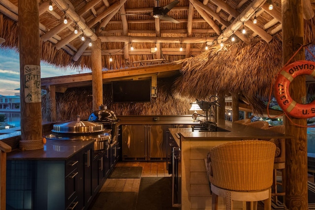 bar with wood ceiling, light wood-type flooring, wood walls, high vaulted ceiling, and beam ceiling