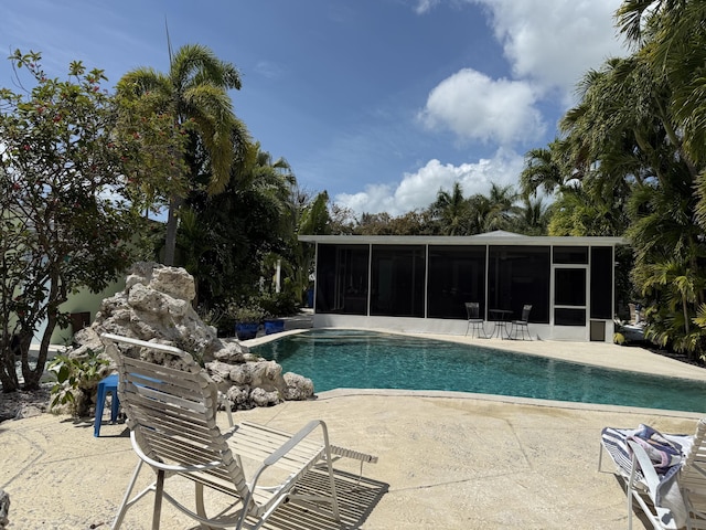 pool featuring a sunroom and a patio area