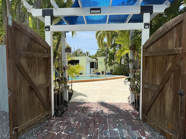 view of gate featuring a patio and a fenced in pool