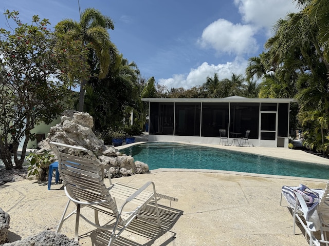 pool featuring a sunroom and a patio