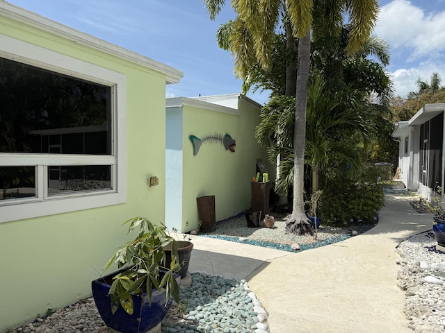 view of side of property featuring stucco siding and a patio