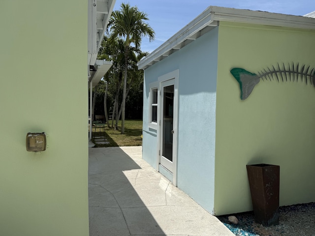 view of side of property featuring stucco siding and a patio