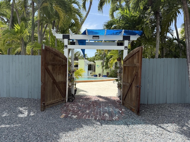 view of gate featuring an outdoor pool and fence