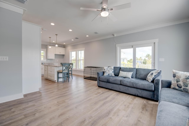 living area with ornamental molding, light wood finished floors, baseboards, and recessed lighting