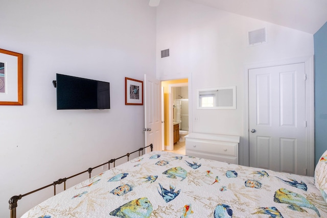 bedroom with ensuite bathroom, high vaulted ceiling, and visible vents