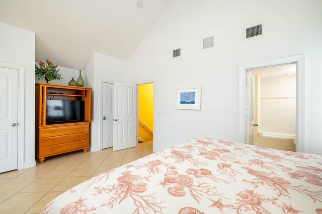 bedroom featuring high vaulted ceiling, visible vents, and light tile patterned floors