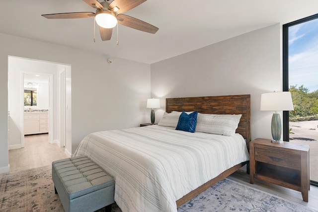 bedroom with a ceiling fan, baseboards, multiple windows, and light wood-type flooring