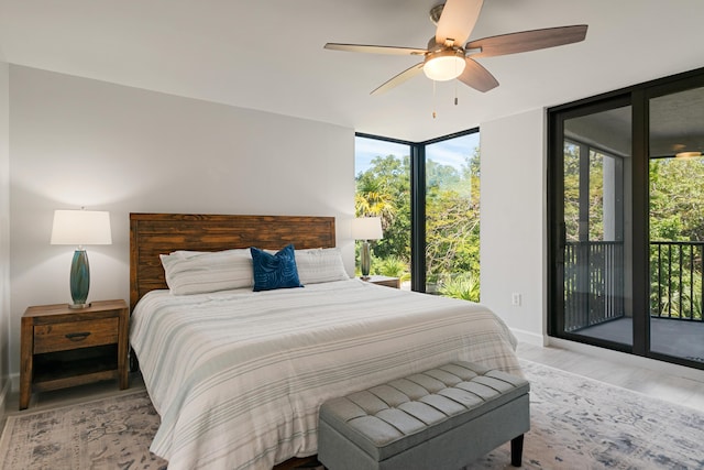 bedroom with a wall of windows, access to exterior, multiple windows, and light wood-style flooring