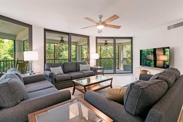 tiled living area with visible vents, a ceiling fan, and a wall of windows