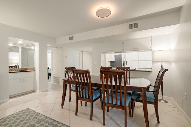 dining space featuring light tile patterned flooring, baseboards, and visible vents