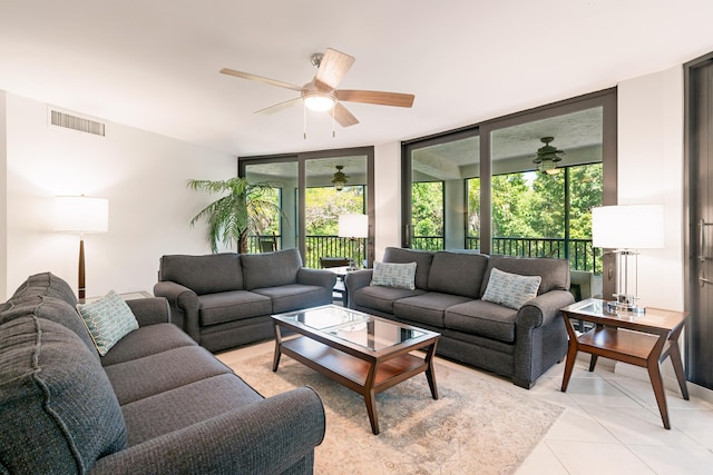 living area with ceiling fan, visible vents, light tile patterned floors, and a wall of windows