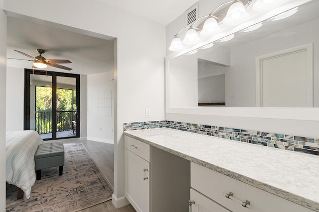 bathroom with vanity, decorative backsplash, visible vents, a ceiling fan, and wood finished floors